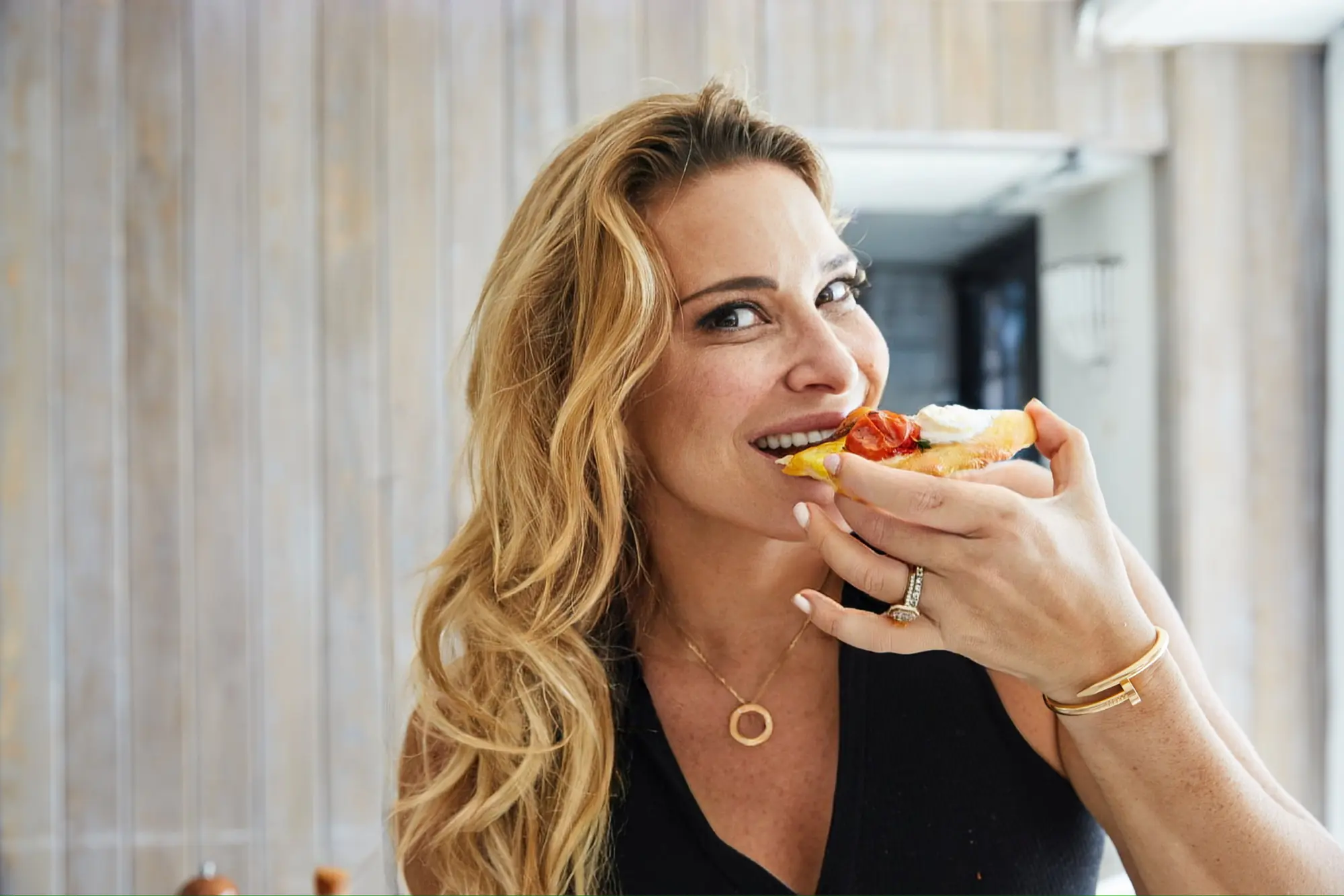 Donatella Arpaia smiling as she takes a bite