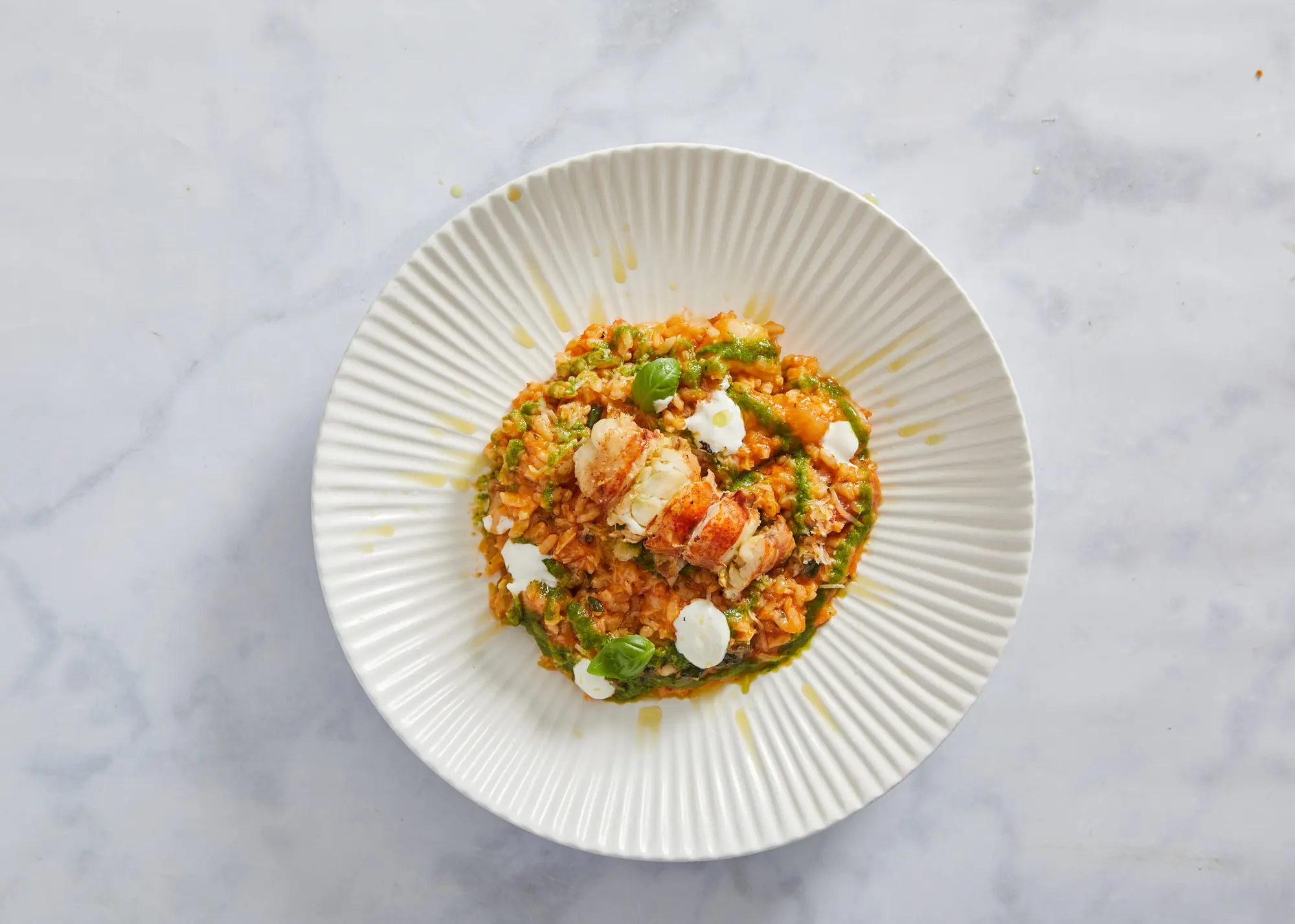 Seafood risotto with shrimp in a white ribbed bowl