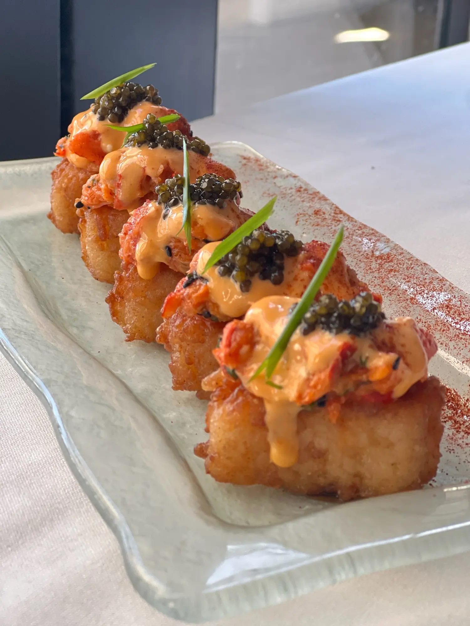 A row of shrimp toasts topped with caviar